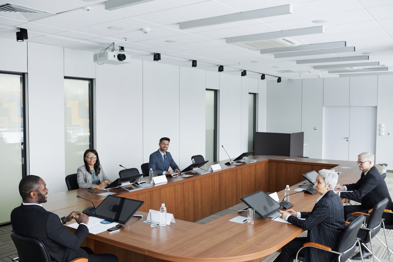 A multicultural group of professionals engaged in a business meeting in a modern conference room.